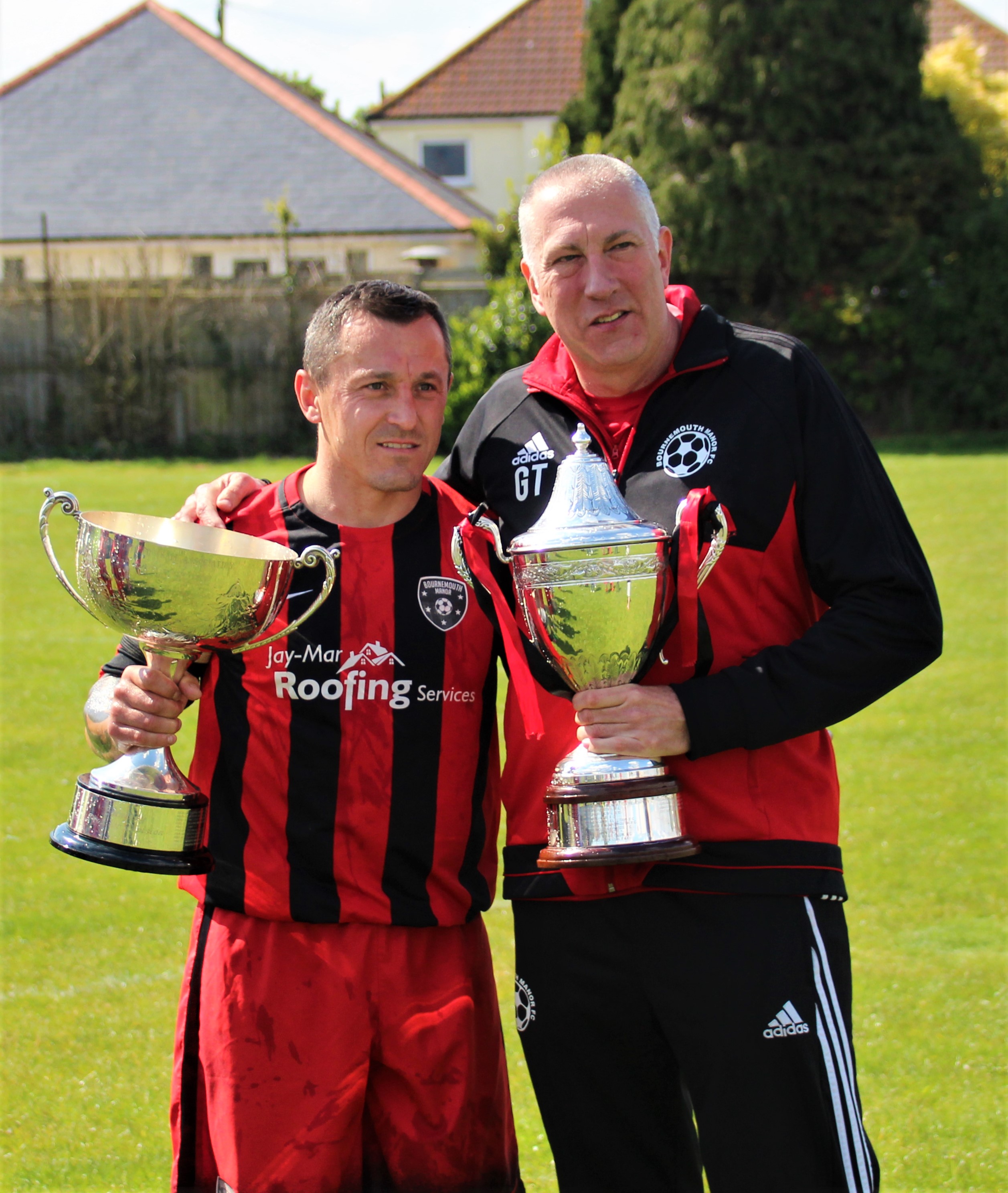 Bmth Manor skipper Darren Spiers and manager Gary Thomas sign off with the Premier Division trophy and the M.A. Hart Poole Bay Cup